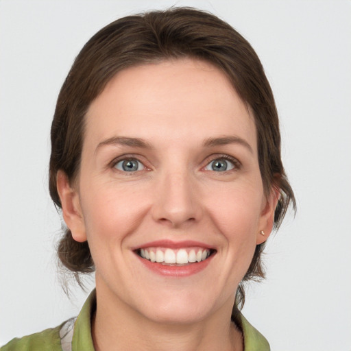 Joyful white young-adult female with medium  brown hair and grey eyes