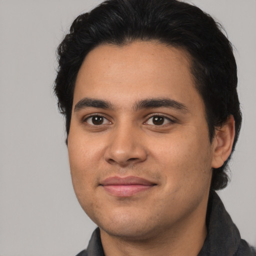 Joyful latino young-adult male with short  black hair and brown eyes