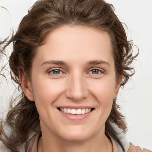 Joyful white young-adult female with medium  brown hair and blue eyes