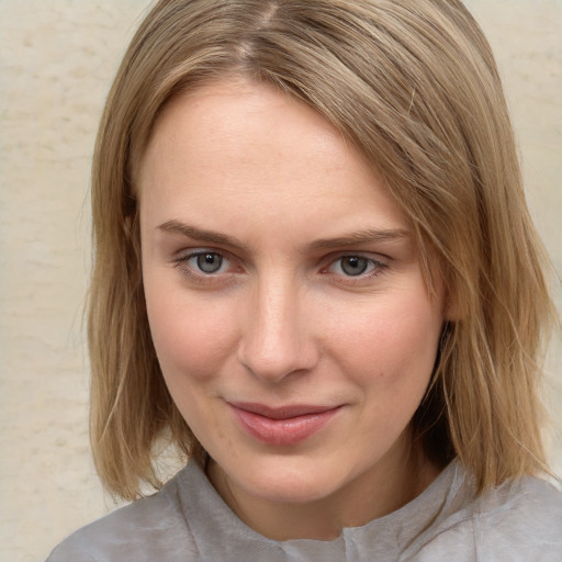 Joyful white young-adult female with medium  brown hair and blue eyes