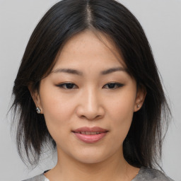 Joyful asian young-adult female with medium  brown hair and brown eyes