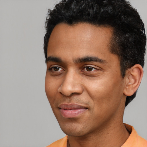 Joyful black young-adult male with short  black hair and brown eyes