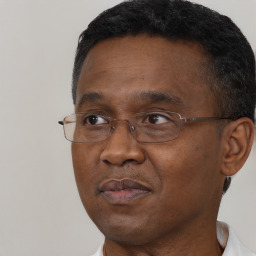 Joyful black adult male with short  brown hair and brown eyes