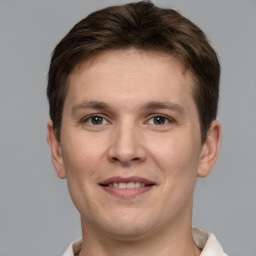 Joyful white young-adult male with short  brown hair and grey eyes