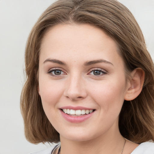 Joyful white young-adult female with long  brown hair and blue eyes