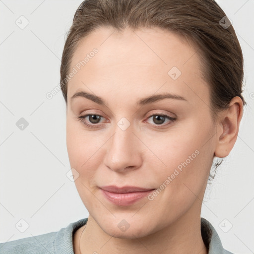 Joyful white young-adult female with short  brown hair and grey eyes