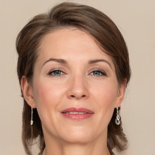 Joyful white adult female with medium  brown hair and grey eyes