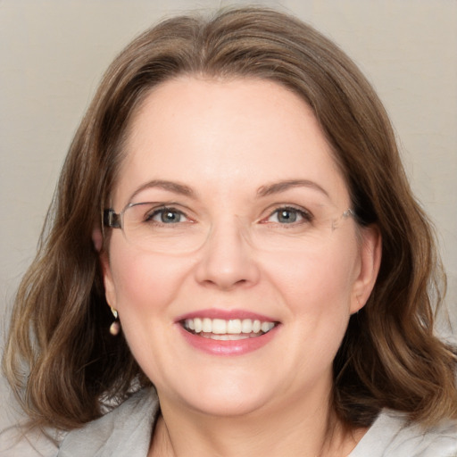 Joyful white adult female with medium  brown hair and green eyes