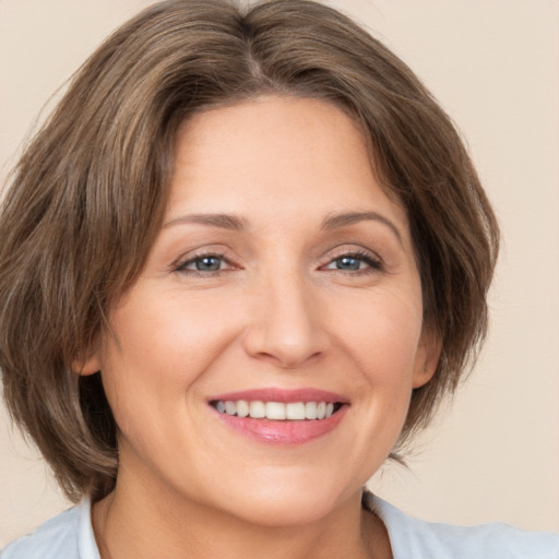 Joyful white adult female with medium  brown hair and brown eyes