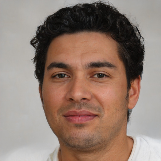 Joyful latino young-adult male with short  black hair and brown eyes