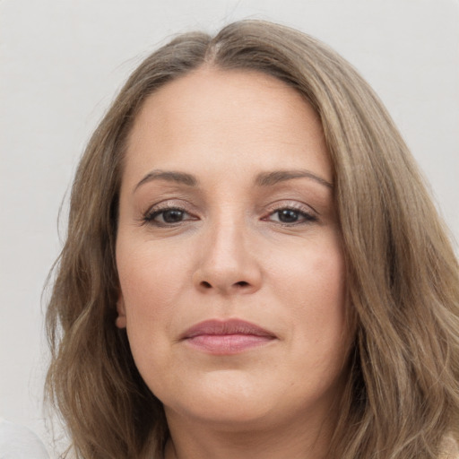 Joyful white adult female with long  brown hair and brown eyes