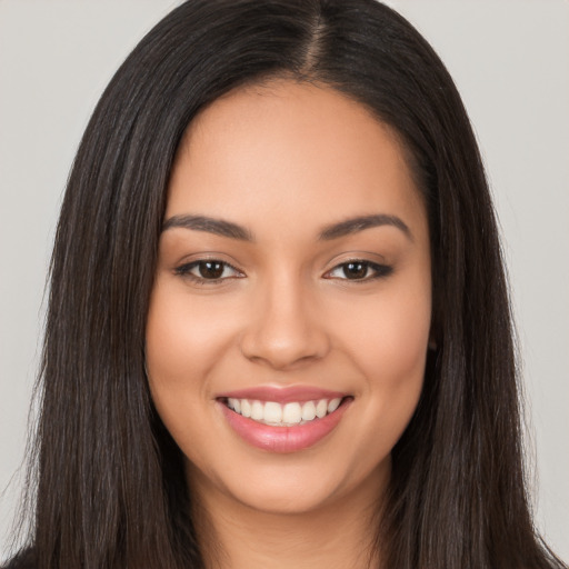 Joyful latino young-adult female with long  brown hair and brown eyes