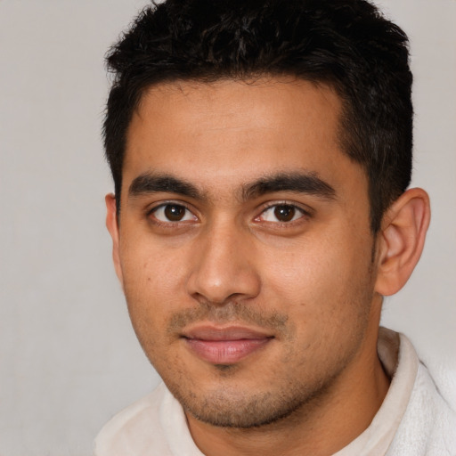 Joyful latino young-adult male with short  brown hair and brown eyes