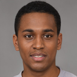 Joyful black young-adult male with short  brown hair and brown eyes