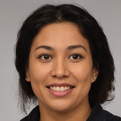 Joyful latino young-adult female with long  brown hair and brown eyes