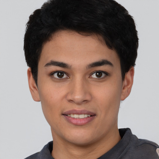 Joyful latino young-adult male with short  brown hair and brown eyes