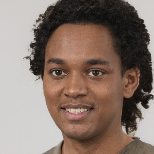 Joyful black young-adult male with short  brown hair and brown eyes
