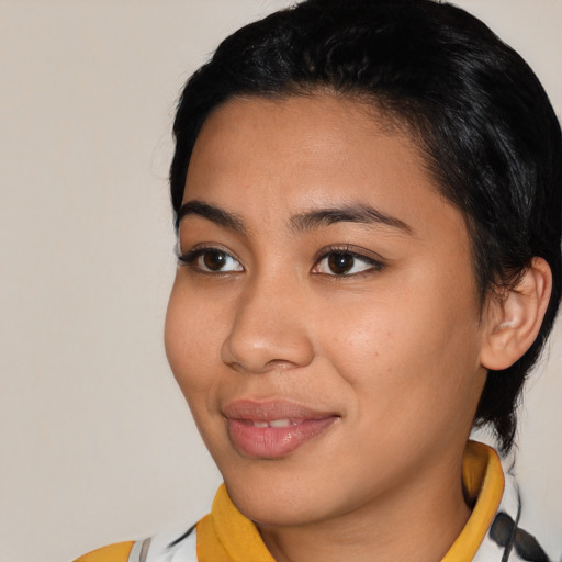 Joyful latino young-adult female with short  black hair and brown eyes