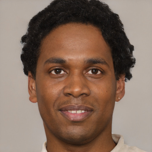 Joyful black young-adult male with short  black hair and brown eyes
