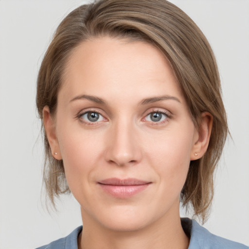 Joyful white young-adult female with medium  brown hair and grey eyes