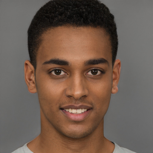 Joyful black young-adult male with short  brown hair and brown eyes
