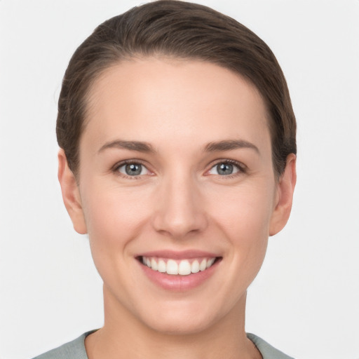 Joyful white young-adult female with short  brown hair and grey eyes