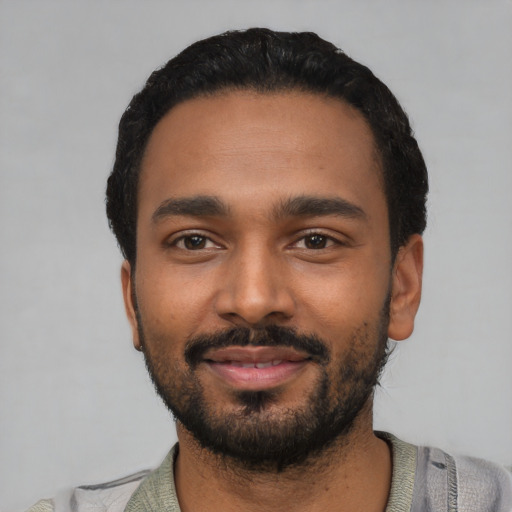 Joyful black young-adult male with short  black hair and brown eyes