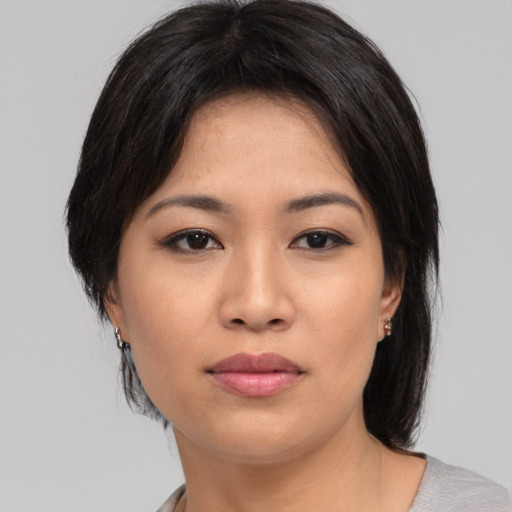 Joyful asian young-adult female with medium  black hair and brown eyes
