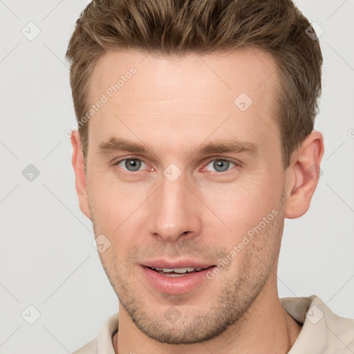 Joyful white young-adult male with short  brown hair and grey eyes