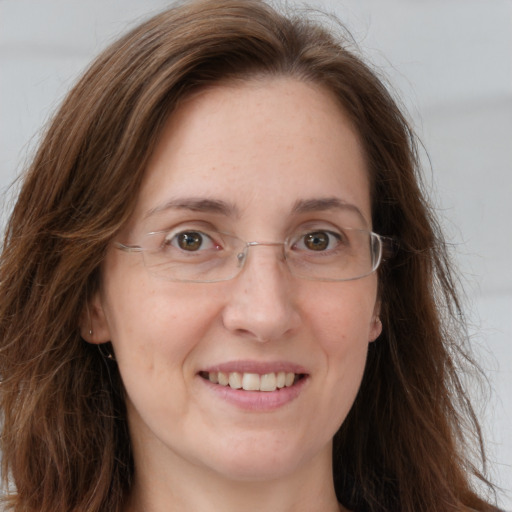 Joyful white adult female with long  brown hair and grey eyes