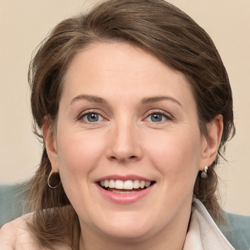 Joyful white young-adult female with medium  brown hair and grey eyes