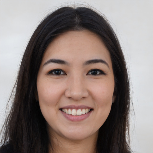 Joyful latino young-adult female with long  brown hair and brown eyes