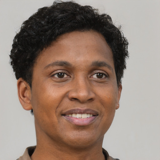 Joyful black adult male with short  brown hair and brown eyes