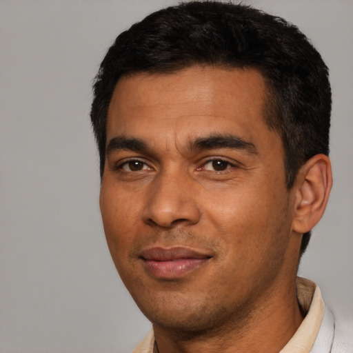 Joyful latino young-adult male with short  black hair and brown eyes