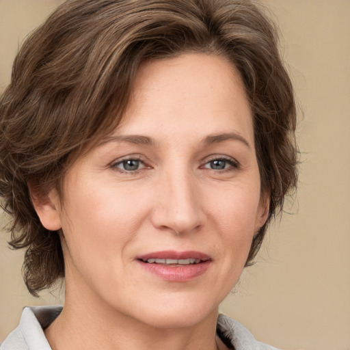 Joyful white adult female with medium  brown hair and green eyes