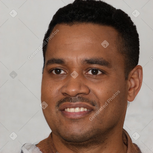Joyful black young-adult male with short  black hair and brown eyes