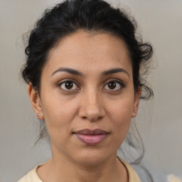 Joyful latino young-adult female with medium  brown hair and brown eyes