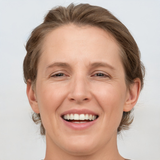 Joyful white adult female with medium  brown hair and grey eyes