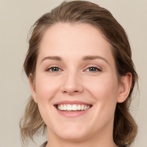 Joyful white young-adult female with medium  brown hair and green eyes