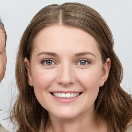 Joyful white young-adult female with long  brown hair and grey eyes