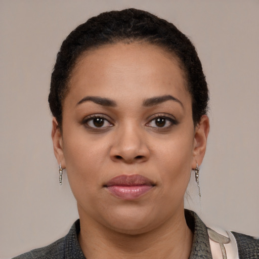 Joyful latino young-adult female with short  black hair and brown eyes