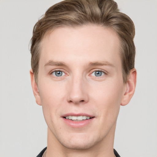 Joyful white young-adult male with short  brown hair and grey eyes