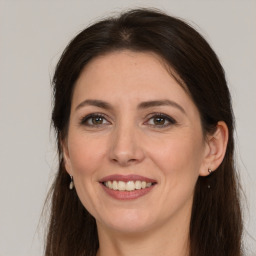 Joyful white adult female with long  brown hair and brown eyes