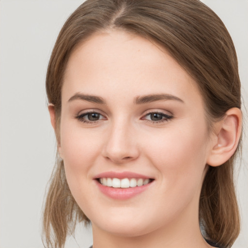 Joyful white young-adult female with long  brown hair and grey eyes