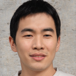 Joyful asian young-adult male with short  brown hair and brown eyes