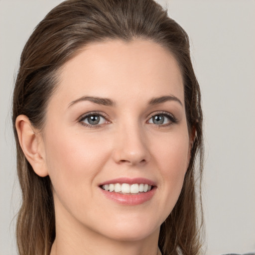 Joyful white young-adult female with long  brown hair and grey eyes