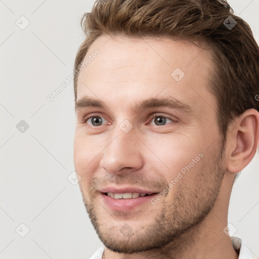 Joyful white young-adult male with short  brown hair and grey eyes