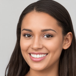 Joyful latino young-adult female with long  brown hair and brown eyes