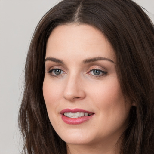 Joyful white young-adult female with long  brown hair and brown eyes