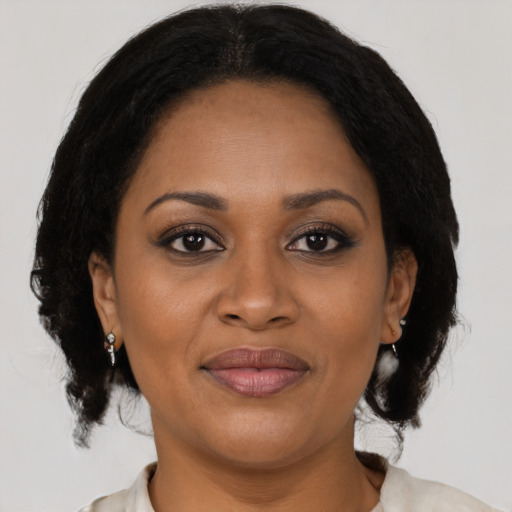 Joyful black adult female with medium  brown hair and brown eyes